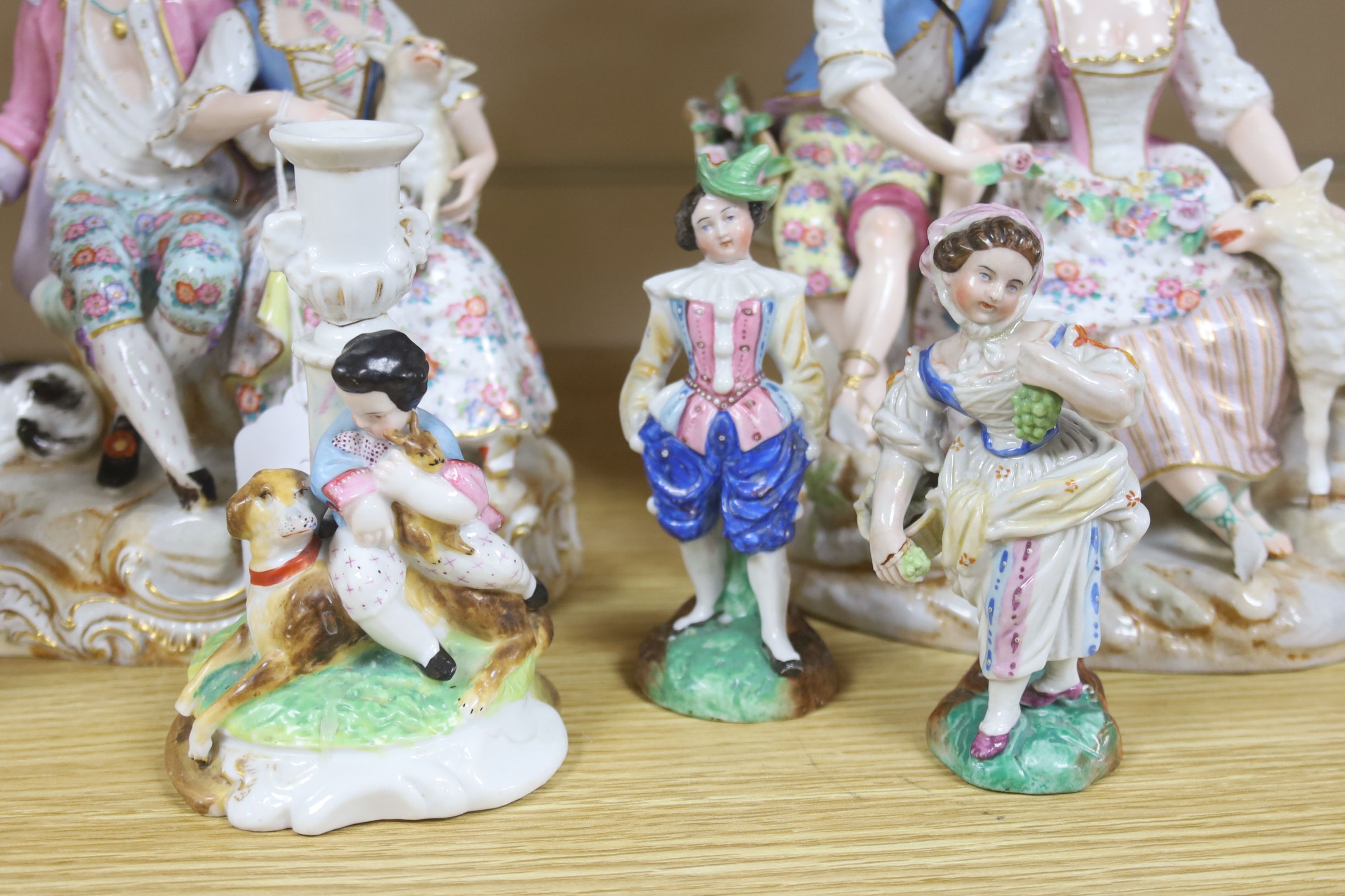 A pair of Meissen style porcelain groups and three other figures, tallest 26cm